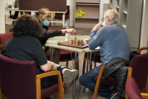 Youth at The Good Fight play chess with an adult mentor